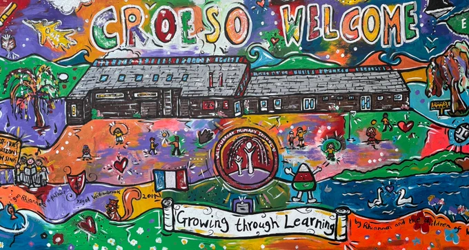 A colourful mural of Willowbrook Primary School, featuring 'CROESO WELCOME' and children playing.