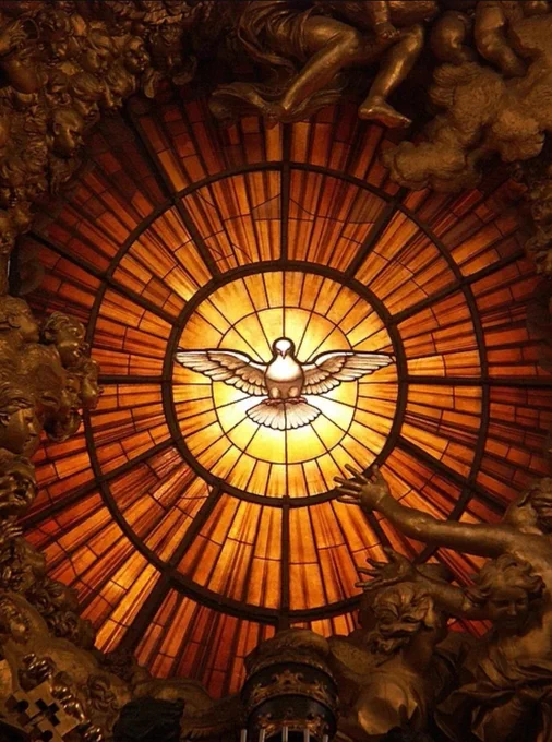 Holy Spirit window by Bernini. It has a dove in the centre surrounded by yellows and oranges radiating out. 
