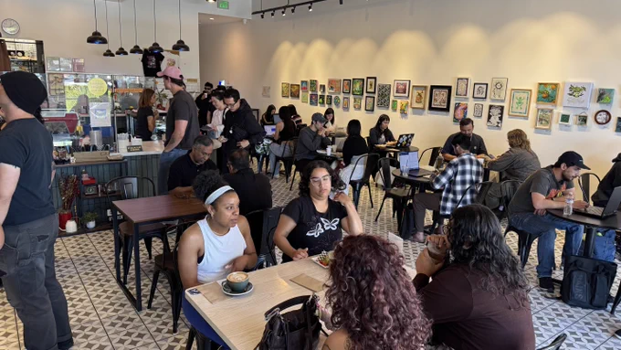 A photo from the front corner of the cafe. It shows the busy restaurant with local art on the far wall.