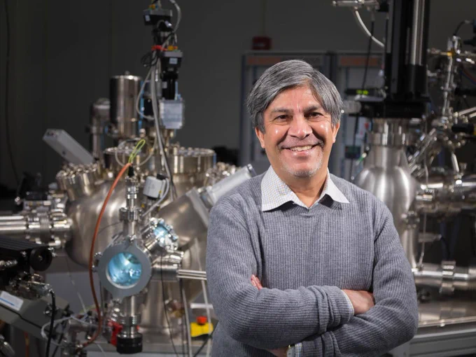 Nitin Samarth standing in front of equipment in his lab.
