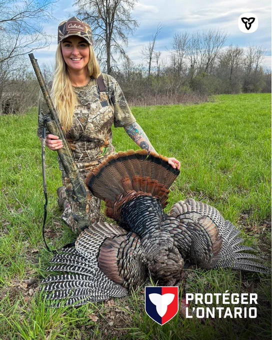 Une chasseuse qui tient un dindon récolté. 