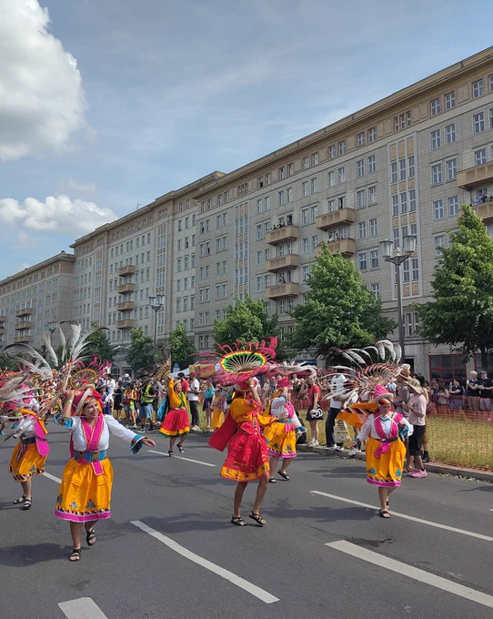 Bolivianische Tanzgruppe mit bunten Kleider und großen Kopfbedeckungen mit Nandu-Federn.