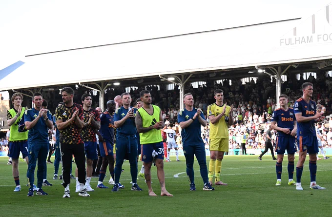 Players and staff applaud supporters at Craven Cottage