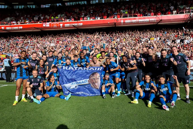 The players celebrate with a Rayan Air flag.