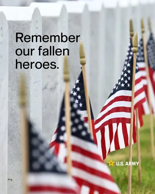 A row of American flags is placed before white military headstones in a cemetery, with the text overlay \"Remember our fallen heroes\" and the U.S. Army logo.