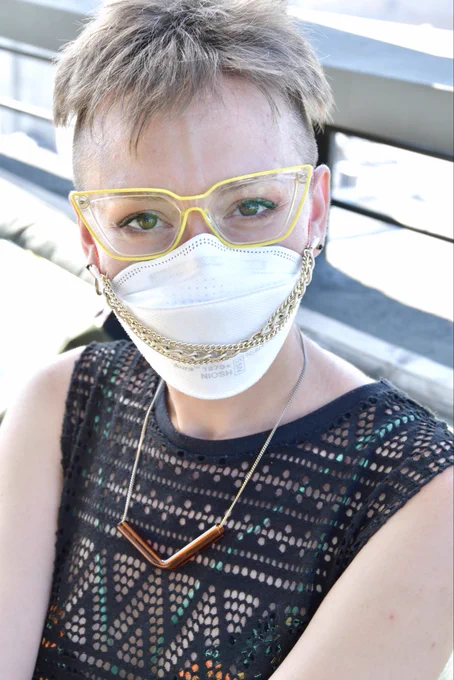 Jamie, wearing a 3M Aura adorned with a gold chain, stylish yellow framed glasses and a see-through black top over a bikini, posed for Julie Lam at a rooptop party hosted by Positive Deviance in NYC.