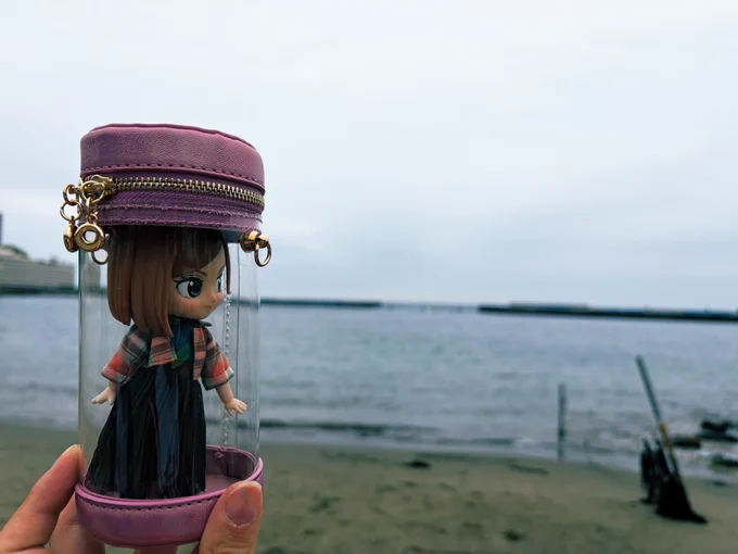 熱海の海を背景に、ドール用ポーチに入った野薔薇ちゃんドールを撮った写真