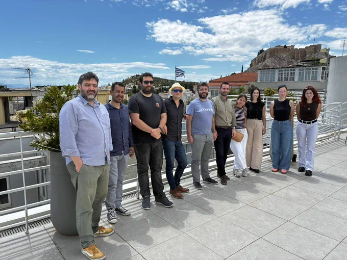 Image shows a group of people standing on a balcony.