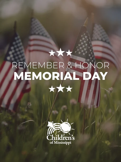 Flags in a field with a blurred background. Text reads "Remember & Honor Memorial Day" with three stars, and "Children's of Mississippi" at the bottom.