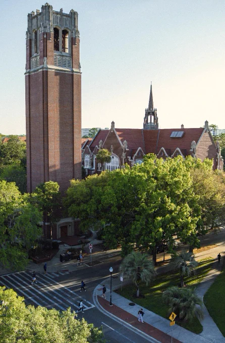 Century Tower and the University Auditorium framed by trees and a crosswalk in front. 