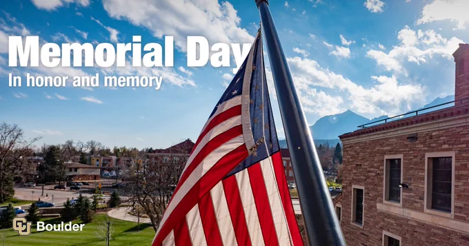 American flag on a pole on a building at CU Boulder, with a clear blue sky and mountains in the background. Text reads, "Memorial Day: In honor and memory."