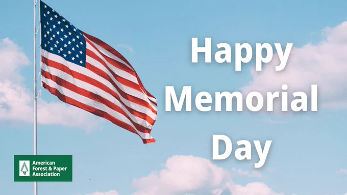 An American flag waving against the sky with text that says Happy Memorial Day.