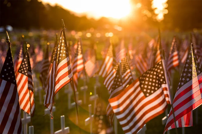 A cemetery lined with rows of small American flag memorial markers. 