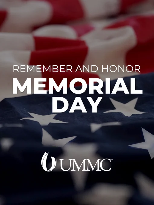 A close-up of an American flag with stars and stripes is in the background. Text in the center reads, "Remember and Honor Memorial Day." The UMMC logo is displayed below.