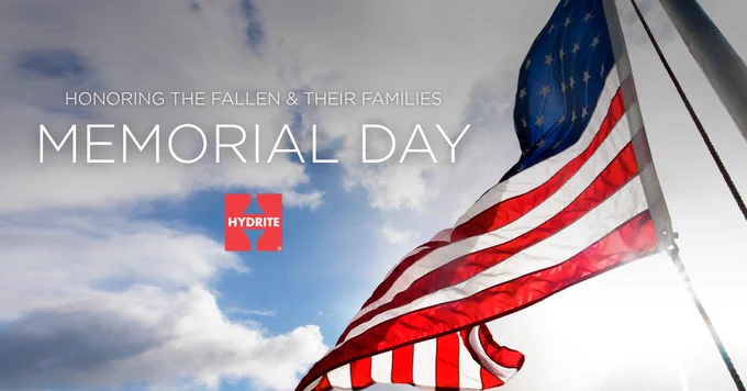 Text: "Honoring the fallen and their families. Memorial Day." Photo of an American flag against a cloudy blue sky.