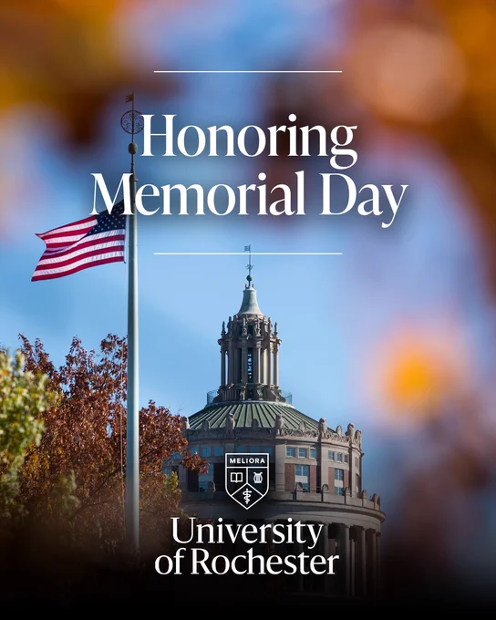 Flagpole with the American flag flying near the Rush Rhees Library dome at the University of Rochester. Text reads "Honoring Memorial Day," with "University of Rochester" and its emblem displayed below. Leaves frame the image.