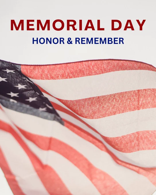 A softly lit graphic featuring a close-up of an American flag gently waving, with its red and white stripes and part of the blue field with white stars visible. Above the flag, bold red text reads “MEMORIAL DAY,” and below it, blue text reads “HONOR & REMEMBER” against a clean white background.