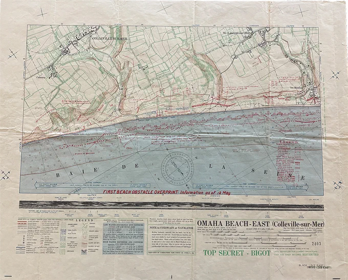 Topographical map including highways, railroads, buildings, and bodies of water. It also includes a red overprint with legend denoting hedgehogs, tetrahedrons, element "c", log ramps, and more. The text reads “Omaha Beach - East (Colleville-sur-Mer)."