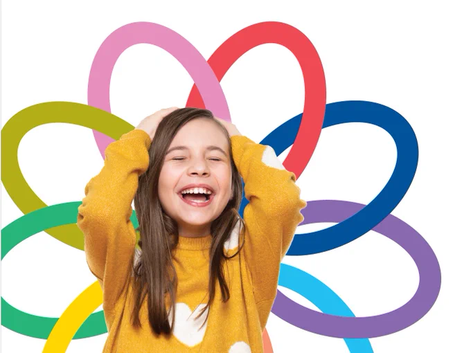 Person in a yellow sweater holding their head with colourful overlapping loops in the background on a white backdrop.