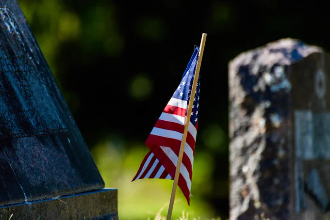 American flag at a cemetery, symbolizing honor and remembrance.