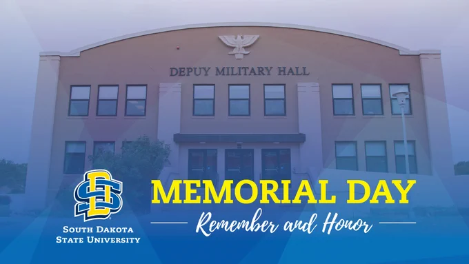 The image shows Deputy Military Hall, a building with a large arched facade. The text "Memorial Day" is in bold yellow letters with "Remember and Honor" underneath in white script. The South Dakota State University logo is in the lower left corner.