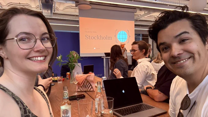 Sofia and Cesar in the foreground sitting at a table with other entrepreneurs at Kvadrat office in Stockholm