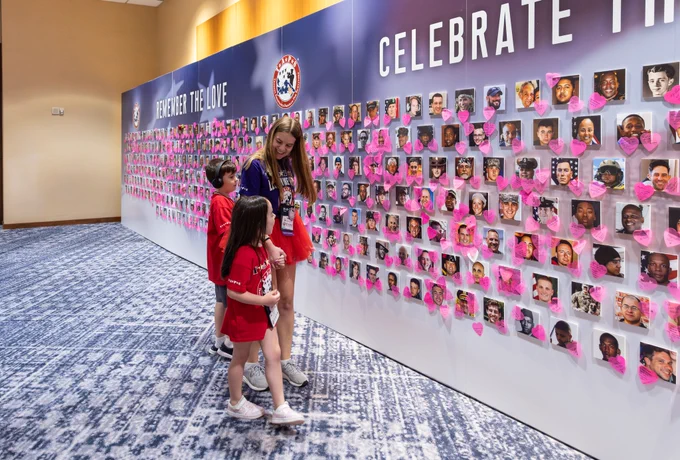 Members of the Tragedy Assistance Program for Survivors visit a wall of remembrance that celebrates the lives of fallen loved ones at the 32nd annual TAPS grand banquet in Arlington, Va., on May 23, 2026. (Courtesy of TAPS)