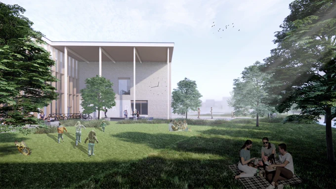 Modern building with large windows beside a grassy park where children play and people relax under trees on a sunny day.