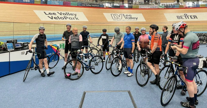Group of cyclists standing with bikes on the track at Lee Valley VeloPark.