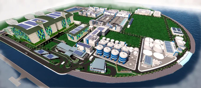 Aerial view of a modern industrial complex with multiple buildings, storage tanks, and green spaces by the water.