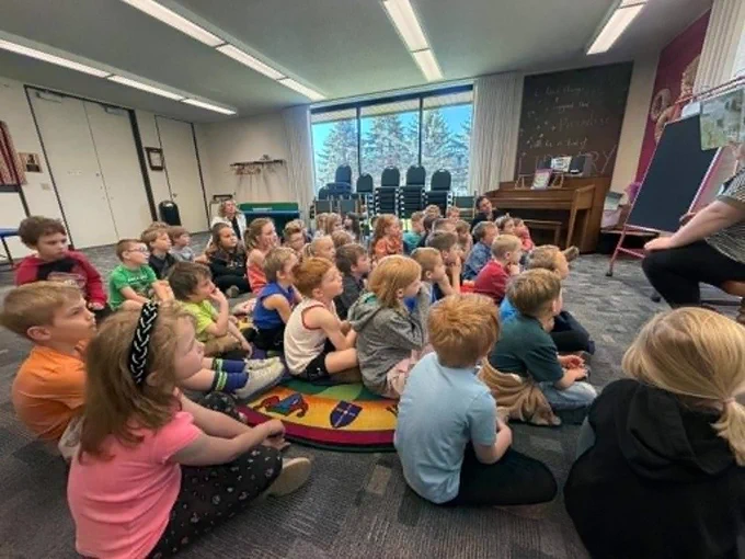 The librarian reading the kids a story at the library