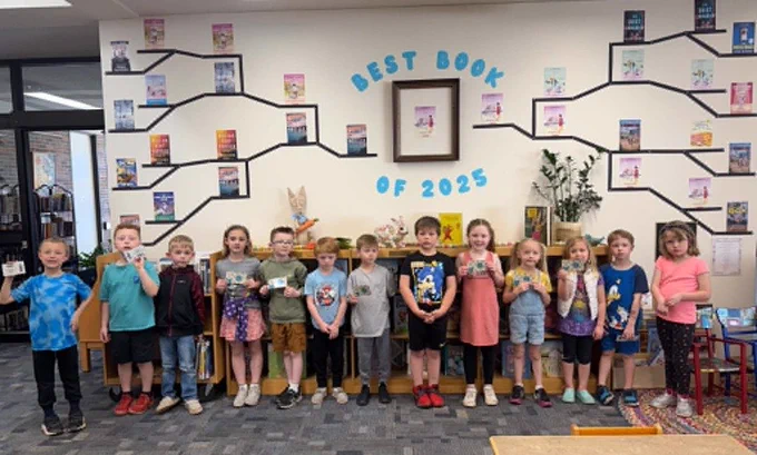 some kindergartners at the library holding a card