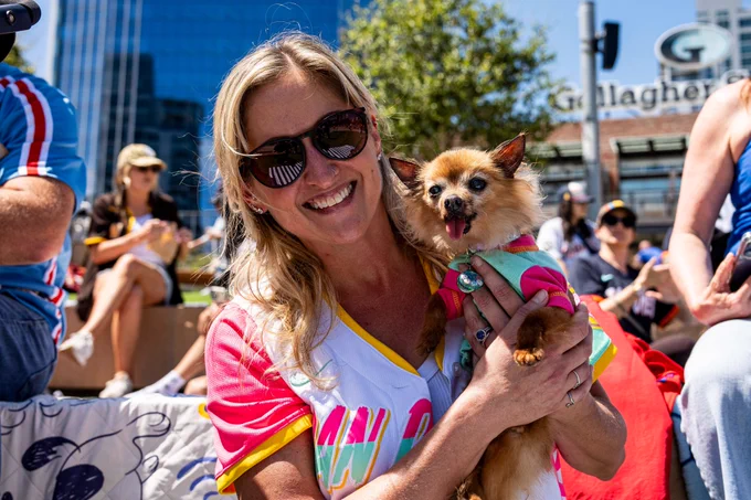 Photo of a Padres fan holding their dog in Gallagher Square at Bark at the Park.