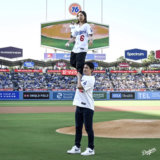 A photo of Ryuichi Kihara holding up Riku Miura for the honorary first pitch.