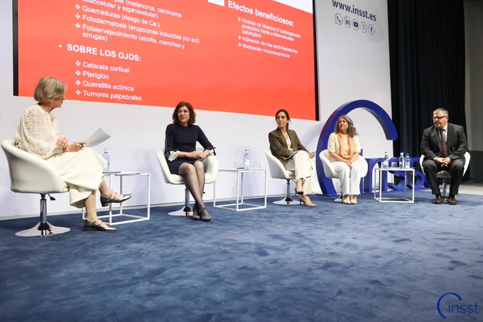 Moderadora de una de las mesas y personas ponentes sentadas en el escenario.