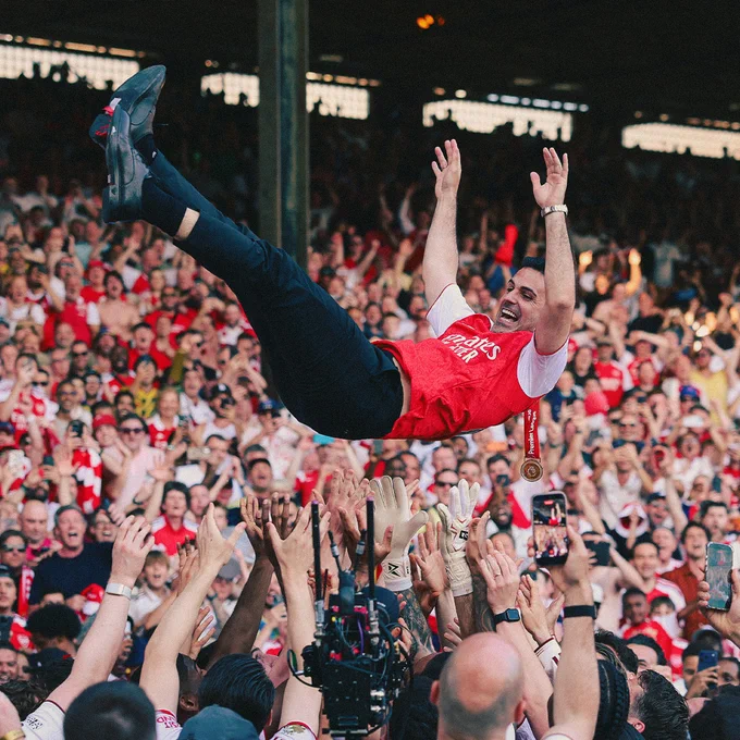 Mikel Arteta is thrown in the air in celebration by his Arsenal team.