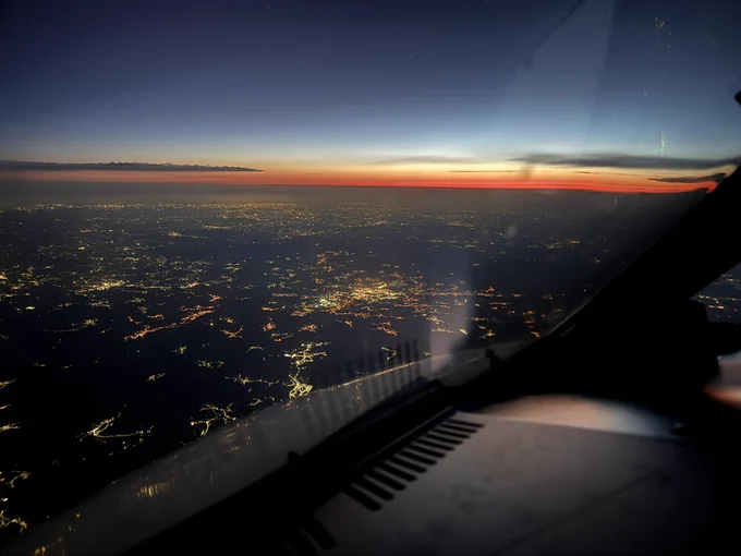 Descending into Porto with the remaining red colors of the sunset an hour before on the horizon. Below the lights of the cities and villages in Northern Portugal.