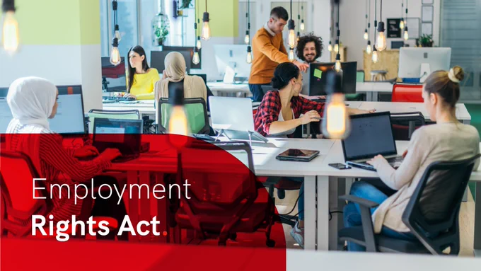 Diverse group of professionals collaborating in a modern office with laptops and desktop computers. In the lower left is a semi-opaque red curved overlay with the words 'Employment Rights Act' in white.