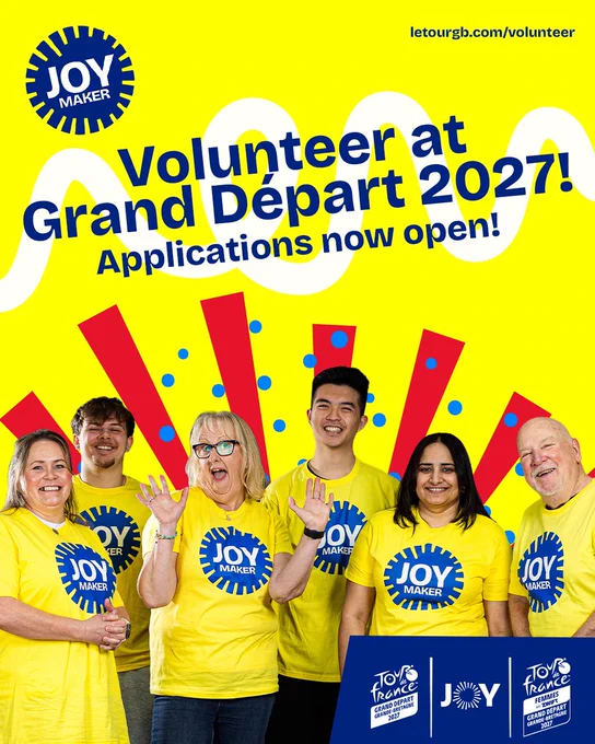 Promotional poster showing a group of people in yellow “Joy Maker” t-shirts against a bright yellow background, advertising volunteering for the 2027 Grand Départ with bold blue text and colourful graphic shapes.
