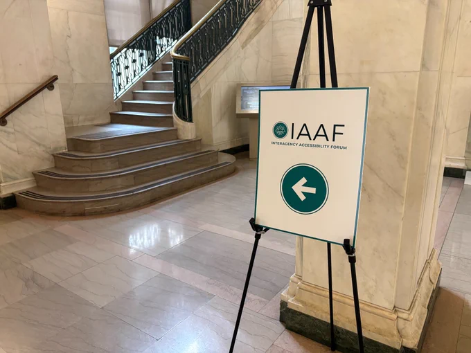 A directional sign stands in the lobby of GSA and points toward the left. The sign reads: IAAF, Interagency Accessibility Forum.