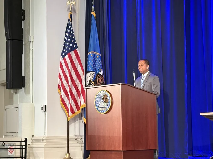 Sachin Pavithran delivers remarks on stage at the event.