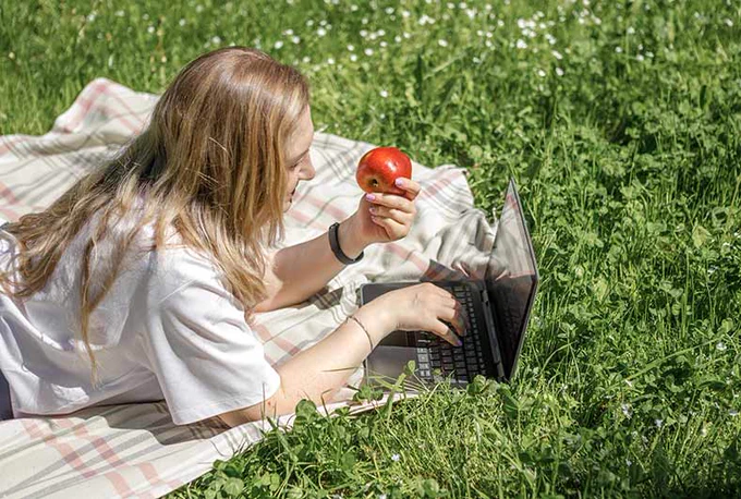 Someone working outside on their laptop during the hot weather. 