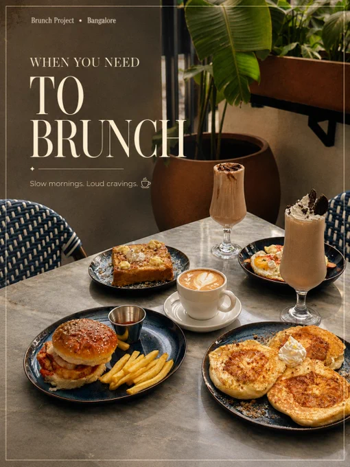 Aesthetic brunch café interiors and lifestyle moments at The Brunch Project in Koramangala, Bangalore. The collage-style visuals showcase cozy marble-top café seating with woven blue chairs, warm natural sunlight, hanging plants, and elegant neutral-toned interiors designed for relaxed brunch experiences. One image features a specialty coffee cup with soft latte art beside dried flowers and typography reading “When you need to catch up.” Another shows guests enjoying a board game and brunch session with the line “When you need to stay a little longer,” highlighting the café’s warm social atmosphere. The final visual displays a full brunch spread with pancakes, burgers, milkshakes, eggs, coffee, and comfort food plates styled on a marble table surrounded by lush greenery. The mood is cinematic, cozy, and inviting, reflecting Bangalore’s modern café culture and the experience of slow mornings, meaningful conversations, specialty coffee, and long brunch catch-ups at The Brunch Project.