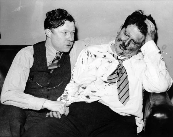 Walter Reuther comforts Richard Frankensteen following their assault by Ford Service Department employees during the “Battle of the Overpass”. The men were beaten and tossed down a flight of stairs for distributing United Auto Workers leaflets outside of the Ford Rouge Plant, Dearborn, Michigan.