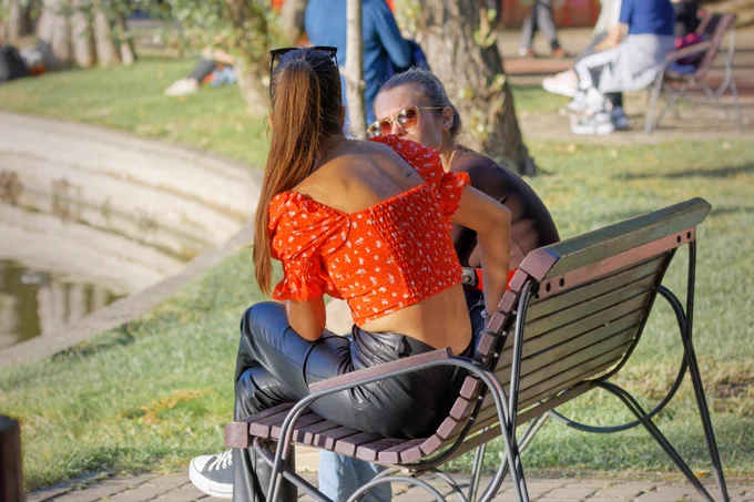 Two women sitting on a bench talking