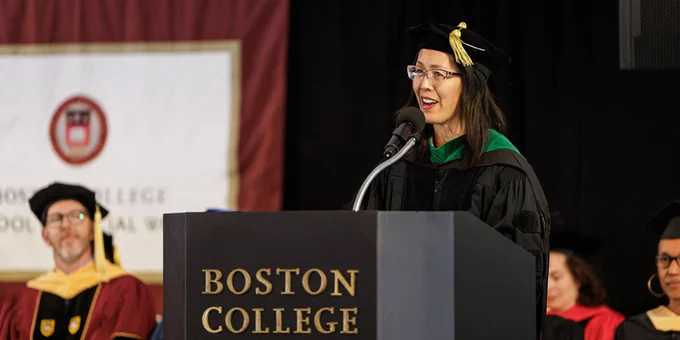 Ann Hwang, president of the Atrius Health Equity Foundation, in cap and gown, delivers the keynote address at BCSSW's diploma ceremony. 