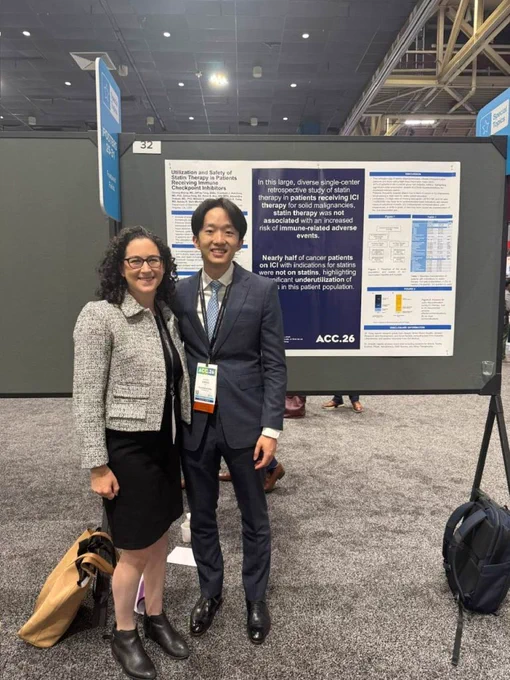Two conference attendees pose in front of an American College of Cardiology Scientific Sessions 2026 research poster about statin therapy in patients receiving immune checkpoint inhibitors, standing in a poster hall with meeting signage overhead.