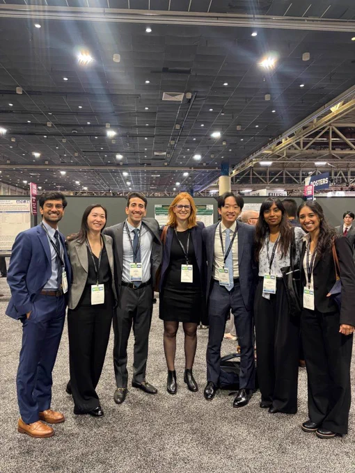 Group photo of conference attendees wearing badges, standing together in a poster hall beneath bright ceiling lights at the American College of Cardiology Scientific Sessions 2026.