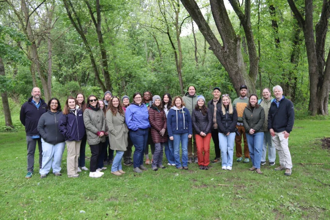 A group of people standing together outside, posing for a picture. 