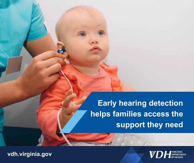 Healthcare professional fitting a hearing device on a young child to support early hearing detection.